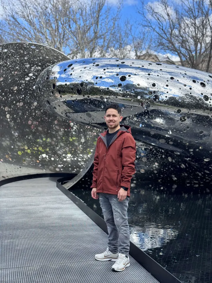 Andres next to a silver sculpture